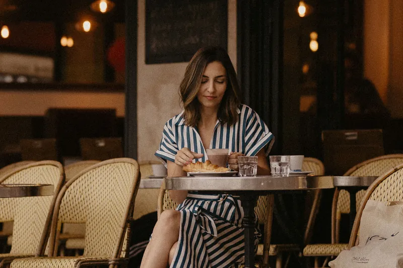 Mel Rolan à mesa de um café parisiense