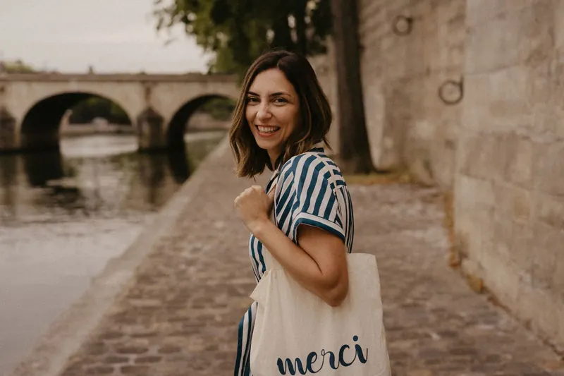 Mel Rolan sorrindo às margens do Sena, em Paris