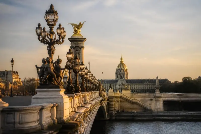Pont Alexandre III ao entardecer, com a cúpula dos Invalides ao fundo